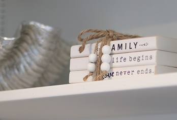 Decorative shelf styling with stacked books and rope, neutral home décor.