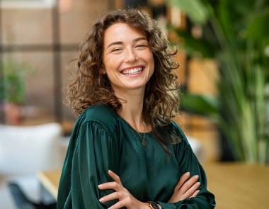 Young woman smiling after professional teeth whitening treatment at dental practice in Aurora, IL.