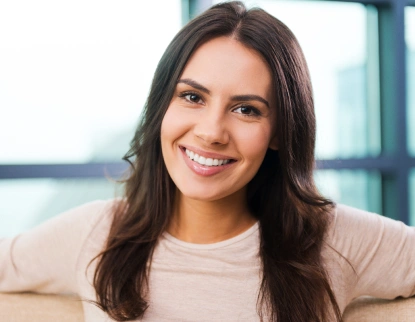 Woman smiling with natural white teeth after dental veneers at Aurora, IL dental office.