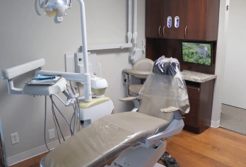 Modern dental treatment room with patient chair, overhead operatory light, and digital monitor at dental office in Aurora.
