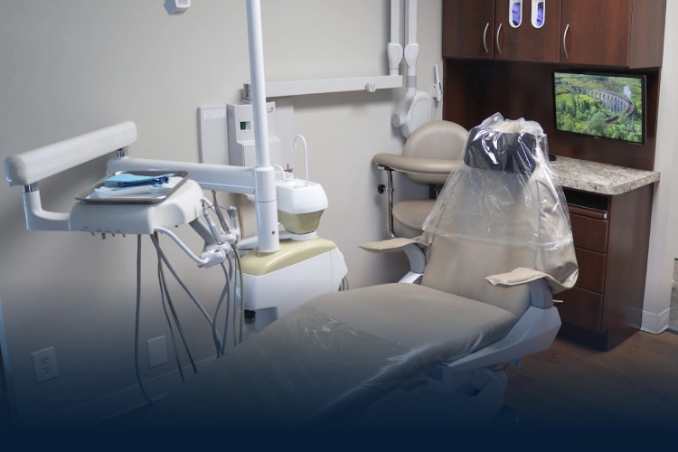 Modern dental treatment room with patient chair, overhead light, and digital display at 1132 Prairie St, Aurora, IL.